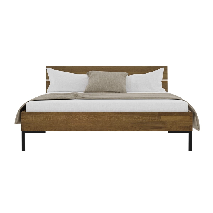 Zbliżenie narożnika łóżka YOKO Style, orzechowy dąb łączony z czarnymi metalowymi nogami w stylu industrialnym