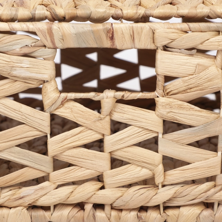 Detal bocznego uchwytu wyciętego w plecionym koszu z hiacyntu wodnego.