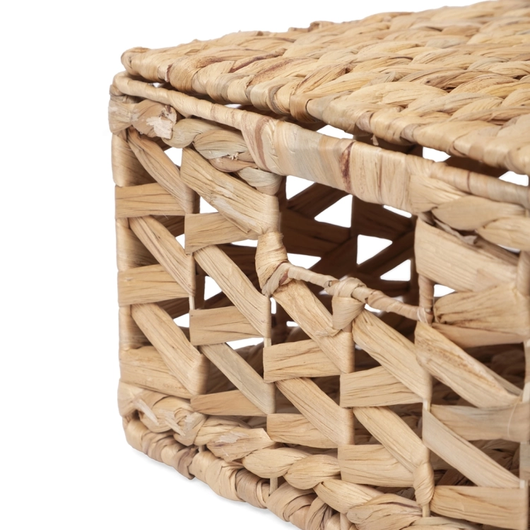 Zbliżenie na krawędź pokrywy i ażurowy wzór plecionki kosza do przechowywania.