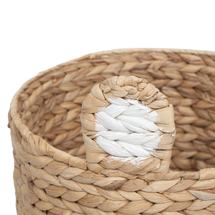 Boczne ucho brązowego kosza do pokoju dziecięcego z widocznym białym malowaniem i naturalnym splotem hiacyntu.