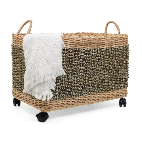 Kosz pleciony z trawy morskiej i rattanu na kółkach z białym kocem, styl boho.