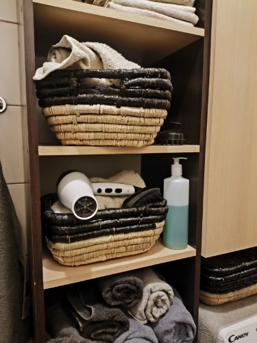 Ozdobny kosz pleciony M, czarno-brązowy, wykonany z hiacyntu wodnego i trawy morskiej. Dwukolorowy design, idealny do przechowywania akcesoriów w łazience lub salonie.