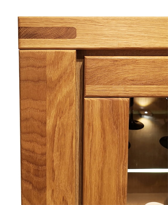 Zbliżenie na precyzyjne łączenie elementów korpusu witryny dębowej Como 2, ukazujące strukturę naturalnego drewna dębu i wysoką jakość wykonania mebla loftowego.